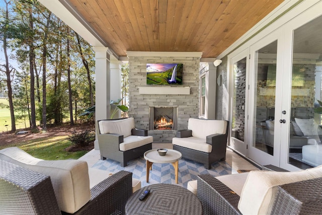 view of patio featuring an outdoor stone fireplace and french doors