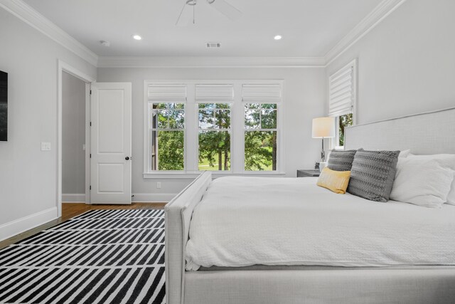 bedroom featuring crown molding, dark hardwood / wood-style floors, and ceiling fan