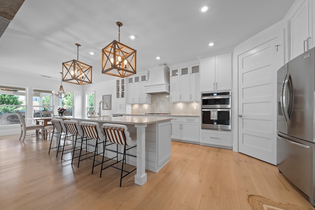 kitchen with stainless steel appliances, custom exhaust hood, a chandelier, recessed lighting, and backsplash