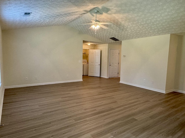 spare room featuring ceiling fan, vaulted ceiling, a textured ceiling, and dark hardwood / wood-style flooring