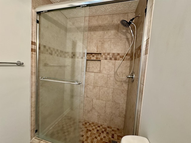 bathroom with toilet and a shower with shower door