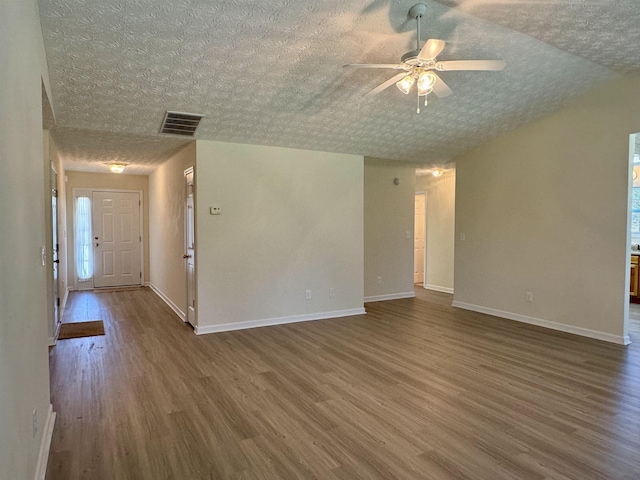 spare room featuring ceiling fan, dark wood-type flooring, and a textured ceiling