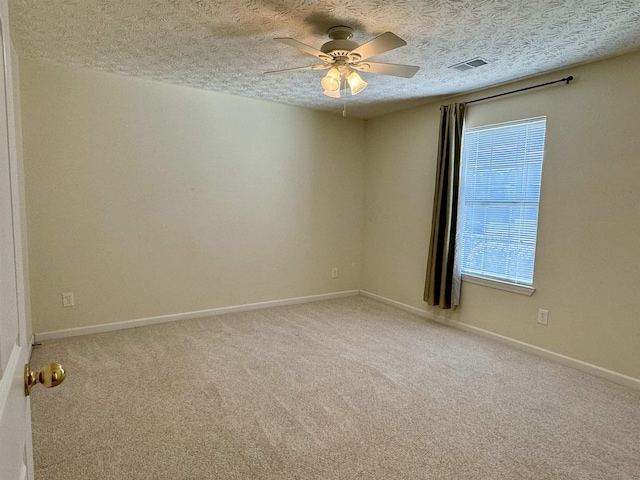 carpeted spare room featuring ceiling fan and a textured ceiling