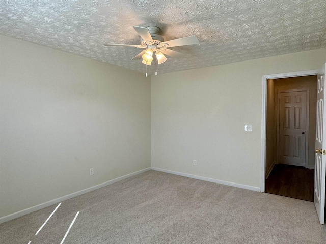 spare room featuring a textured ceiling, ceiling fan, and carpet