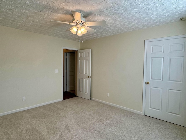 carpeted spare room with ceiling fan and a textured ceiling