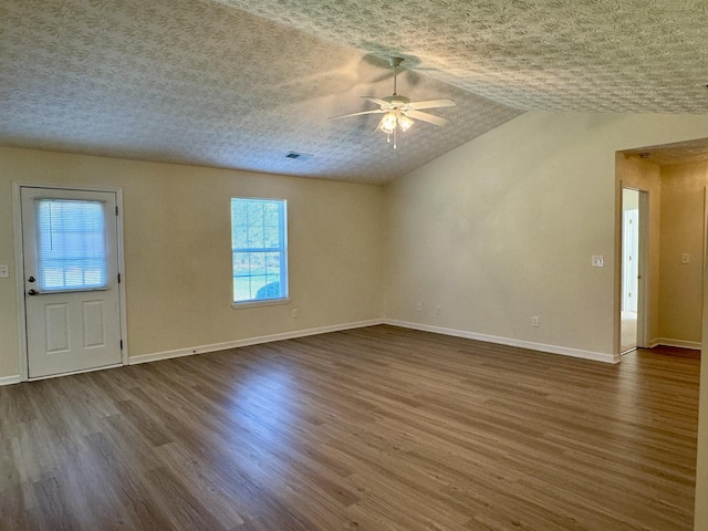 interior space featuring dark hardwood / wood-style flooring, ceiling fan, lofted ceiling, and a textured ceiling