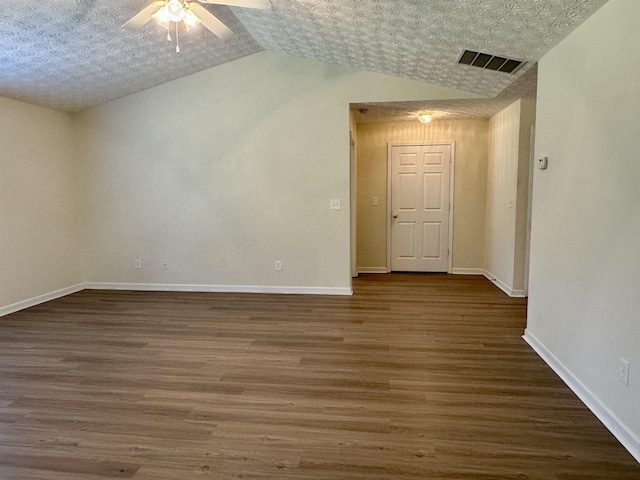 empty room with dark hardwood / wood-style flooring, lofted ceiling, and a textured ceiling