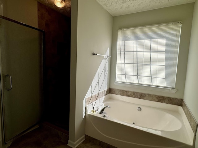 bathroom with independent shower and bath and a textured ceiling