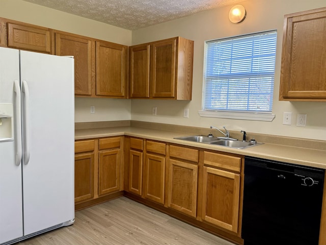 kitchen with dishwasher, sink, white fridge with ice dispenser, light hardwood / wood-style floors, and a textured ceiling