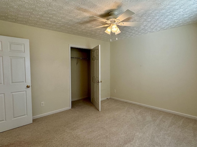 unfurnished bedroom featuring ceiling fan, light carpet, a textured ceiling, and a closet