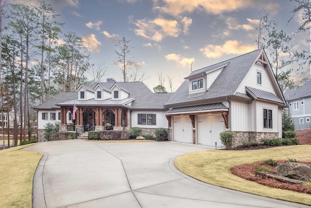 view of front of property featuring a porch, a garage, and a lawn