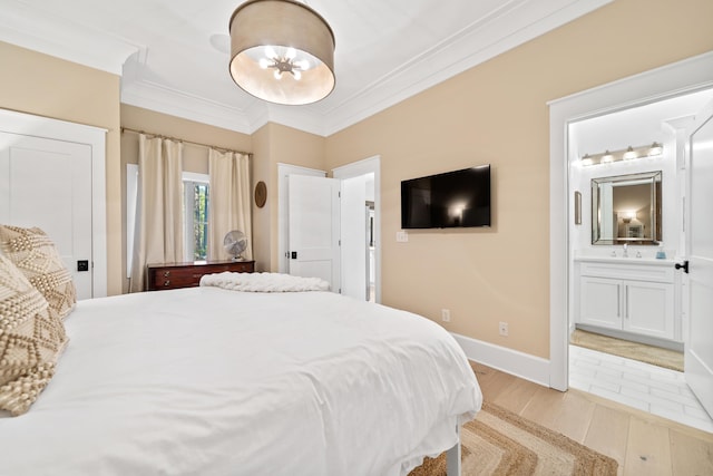 bedroom with baseboards, light wood-style flooring, ensuite bathroom, crown molding, and a chandelier