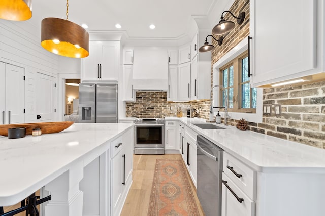 kitchen featuring custom exhaust hood, a sink, decorative backsplash, appliances with stainless steel finishes, and pendant lighting