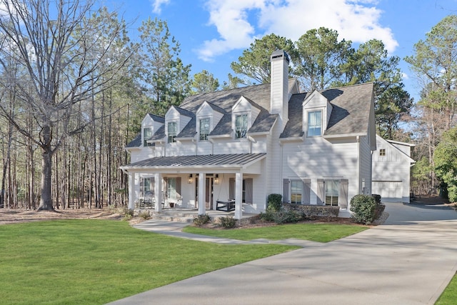 view of front of house with a front lawn, a standing seam roof, covered porch, metal roof, and a chimney