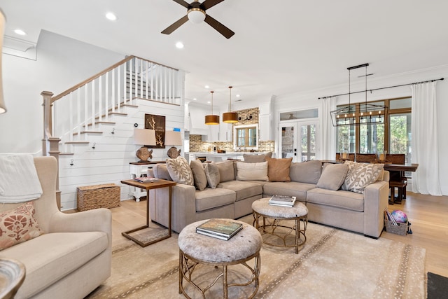 living room featuring light wood-style flooring, recessed lighting, french doors, stairway, and ceiling fan