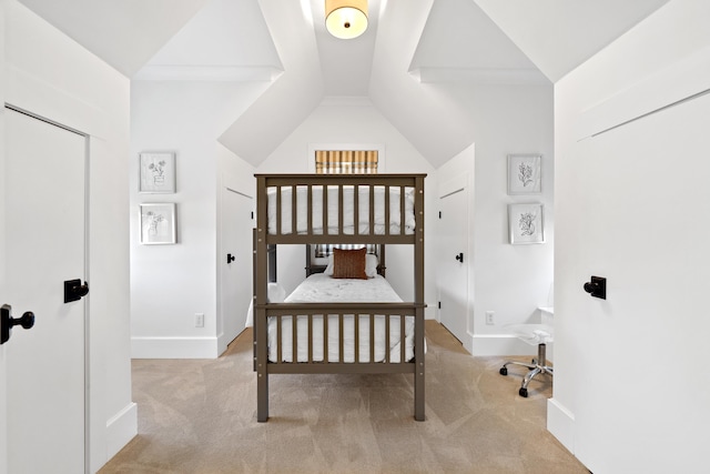 carpeted bedroom with baseboards and vaulted ceiling