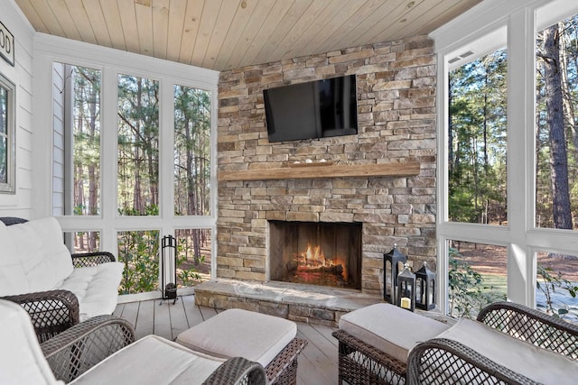 sunroom with wooden ceiling and a fireplace