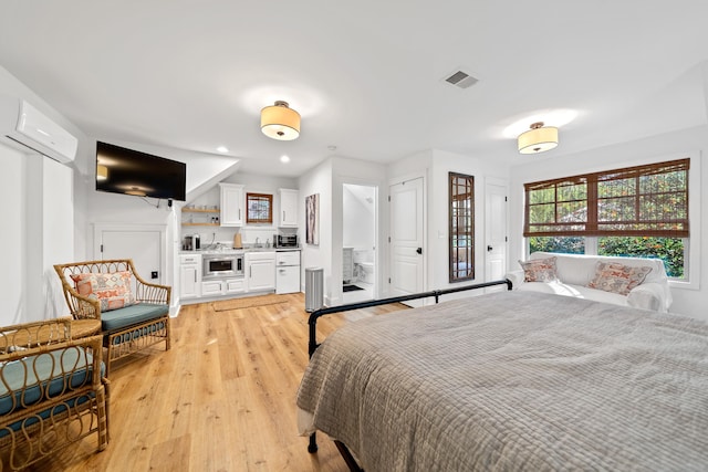 bedroom with recessed lighting, light wood-style floors, visible vents, and a wall mounted air conditioner