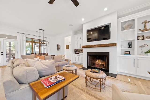 living room featuring ceiling fan, a fireplace with flush hearth, built in features, ornamental molding, and recessed lighting