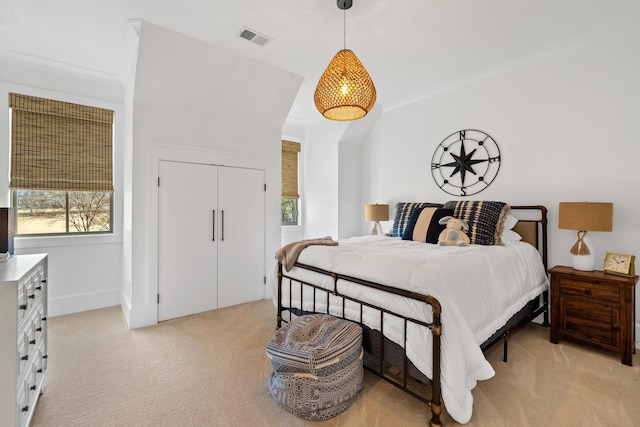 bedroom featuring light carpet, visible vents, and a closet