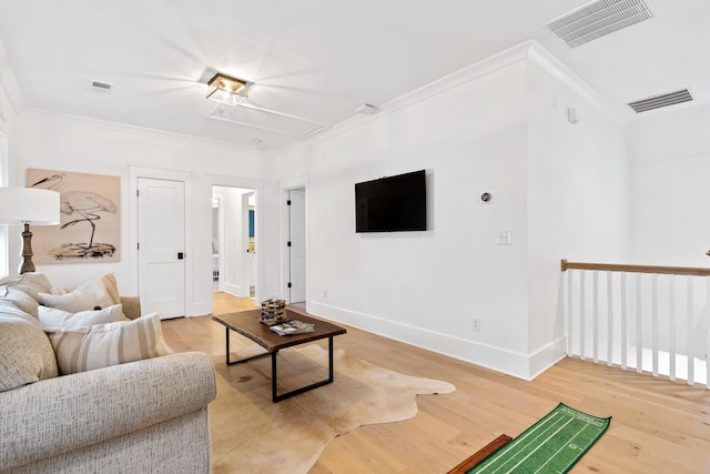 living area featuring visible vents, crown molding, and light wood finished floors