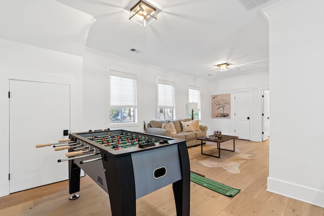 rec room featuring visible vents, light wood-style flooring, crown molding, and baseboards