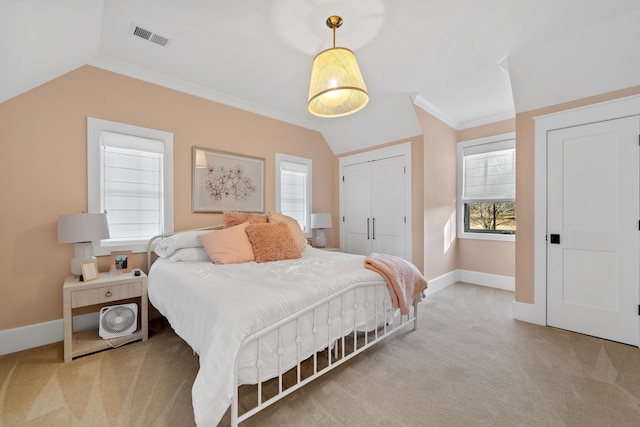 carpeted bedroom with visible vents, crown molding, baseboards, lofted ceiling, and a closet