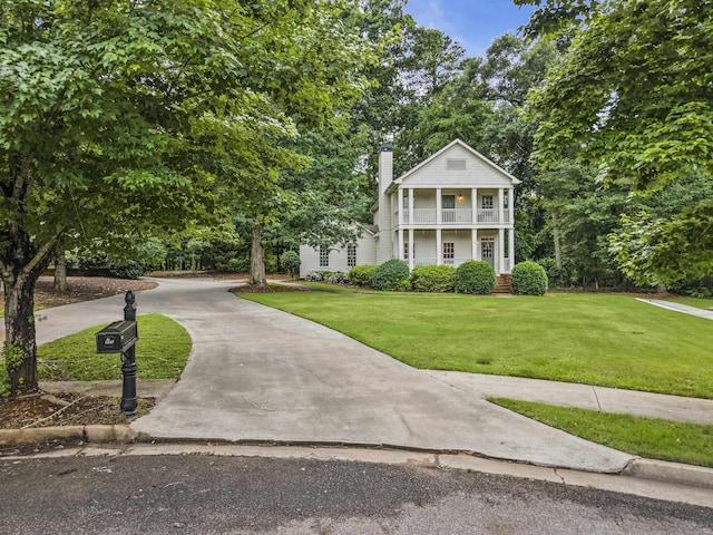 775 Markhams Dr, Madison, GA 30650 - neoclassical home with a balcony, a front lawn, a chimney, and concrete driveway