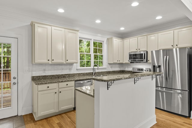 775 Markhams Dr, Madison, GA 30650 - kitchen featuring stainless steel appliances, a sink, tasteful backsplash, dark stone counters, and crown molding