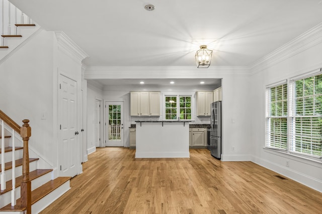 775 Markhams Dr, Madison, GA 30650 - kitchen featuring freestanding refrigerator, light wood-type flooring, baseboards, a center island, and ornamental molding