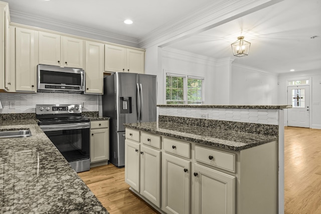 775 Markhams Dr, Madison, GA 30650 - kitchen featuring appliances with stainless steel finishes, light wood finished floors, backsplash, dark stone counters, and ornamental molding