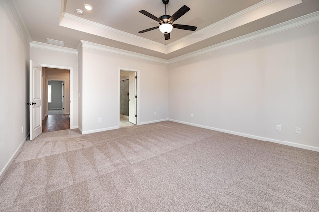 carpeted empty room featuring a raised ceiling, crown molding, and ceiling fan