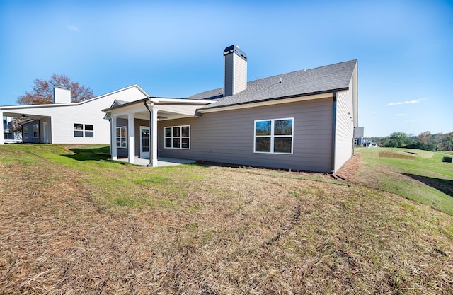 back of house with a lawn and a patio area