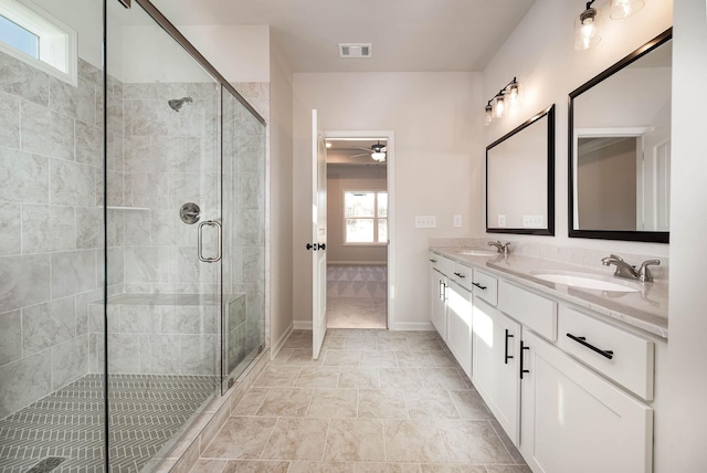 bathroom featuring a shower with door and vanity