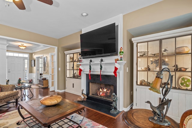 1080 Water Front Rd, Greensboro, GA 30642 - living room with wood-type flooring, a ceiling fan, a wainscoted wall, and a warm lit fireplace