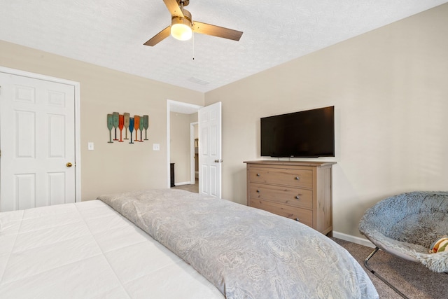 bedroom with a ceiling fan, carpet, a textured ceiling, and baseboards