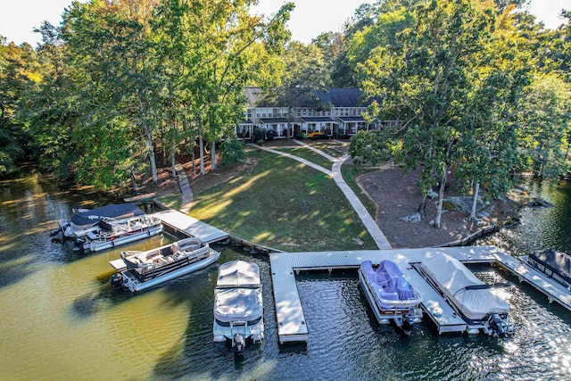 view of dock with a water view and a yard