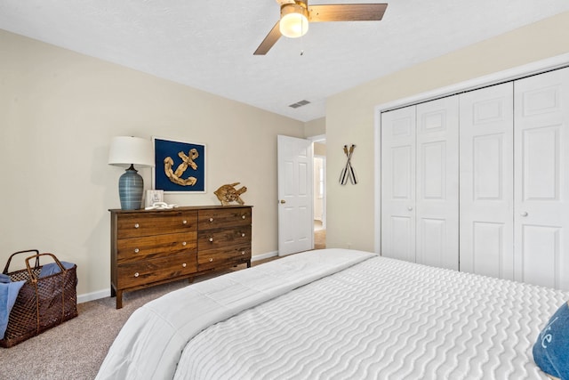 bedroom featuring a closet, visible vents, a ceiling fan, carpet flooring, and baseboards