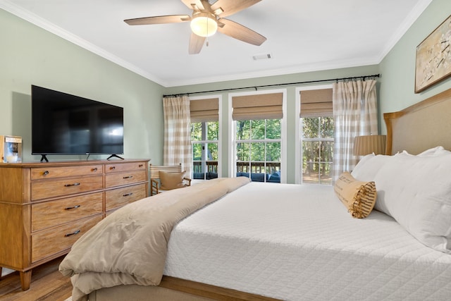 bedroom with a ceiling fan, visible vents, crown molding, and wood finished floors