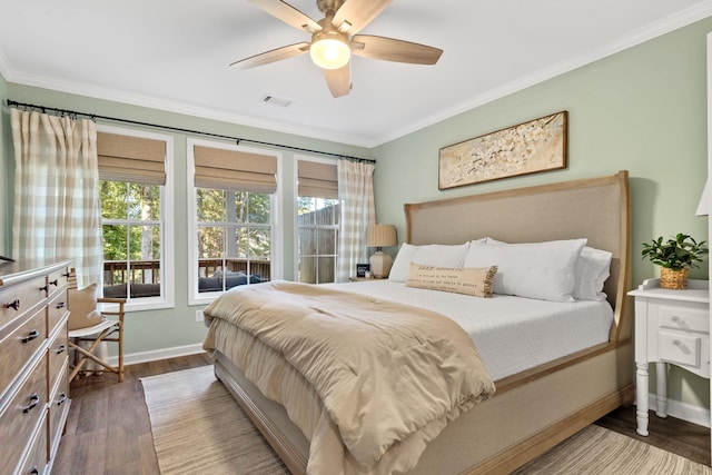 bedroom with dark wood-type flooring, visible vents, ornamental molding, and baseboards