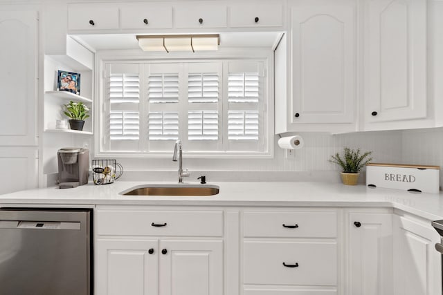 kitchen featuring light countertops, white cabinets, a sink, and stainless steel dishwasher