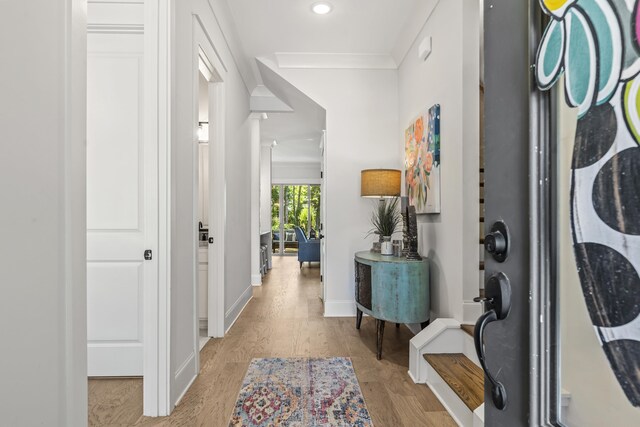 foyer featuring crown molding and light hardwood / wood-style flooring