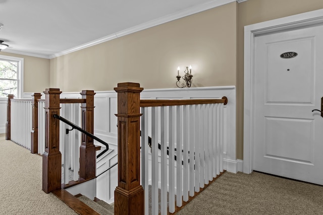 stairs with crown molding and carpet flooring