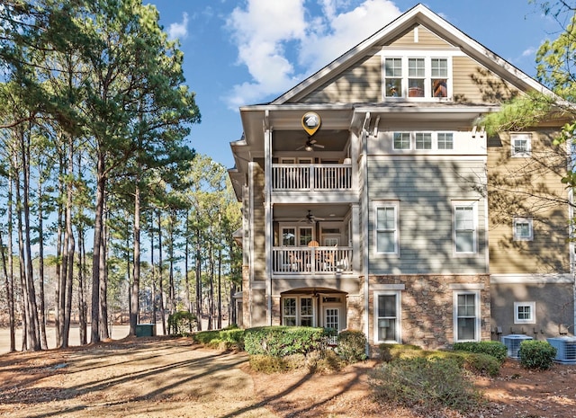 rear view of house with cooling unit, ceiling fan, and a balcony