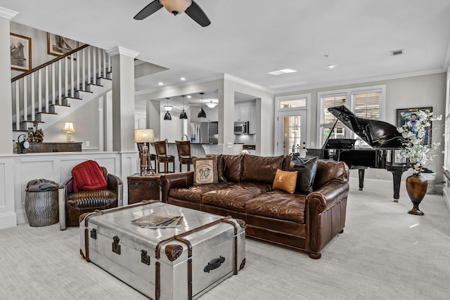 living room featuring crown molding, light colored carpet, decorative columns, and ceiling fan