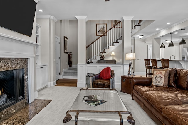 living room with ornamental molding, a fireplace, and light hardwood / wood-style flooring