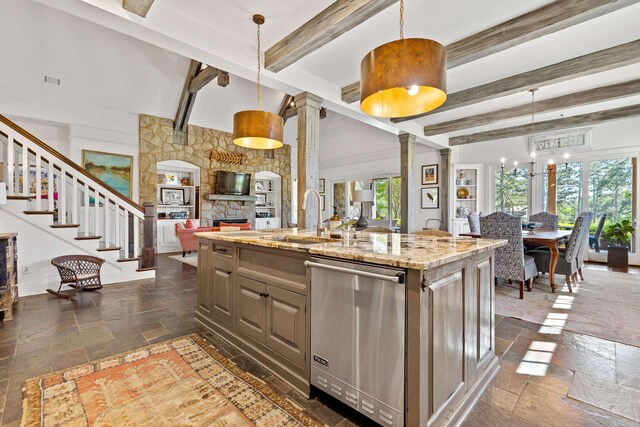 112 Arbors Ln, Eatonton, GA 31024 - kitchen featuring stainless steel dishwasher, a wealth of natural light, stone tile floors, open floor plan, and ornate columns