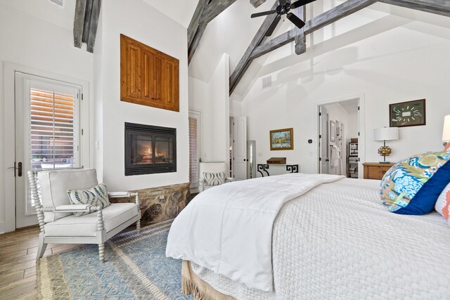 112 Arbors Ln, Eatonton, GA 31024 - bedroom featuring a glass covered fireplace, wood finished floors, visible vents, and high vaulted ceiling