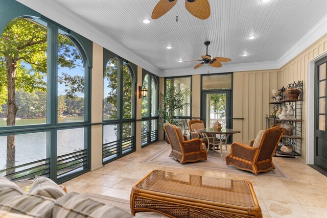 sunroom with a water view and ceiling fan