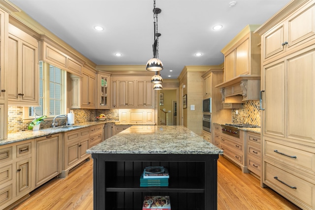 kitchen with appliances with stainless steel finishes, light stone counters, a kitchen island, decorative light fixtures, and light brown cabinets